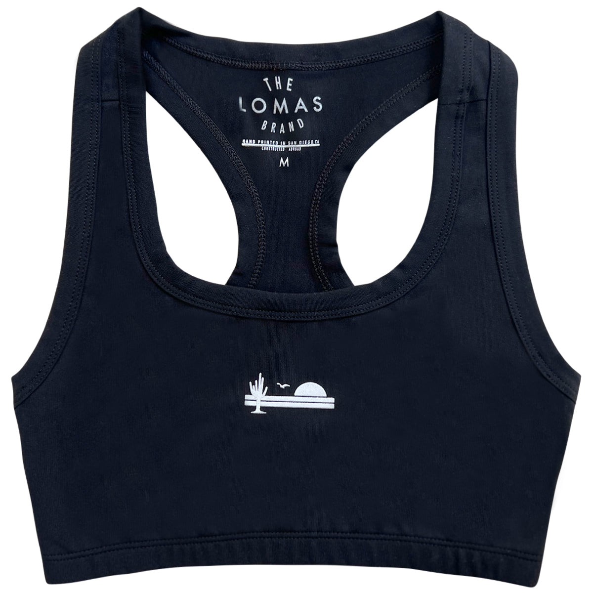 Flat shot of a black sports bra with a white icon showing a saguaro cactus, a bird, and a rising sun in white.