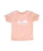 Buttery smooth and soft pink t-shirt for toddlers. An emblematic design graces the shirt, featuring a saguaro cactus, a silhouetted bird taking flight, and an ascending sun, all executed in a striking white tone. Underscoring the emblem is the inscription 'The Lomas Brand'.