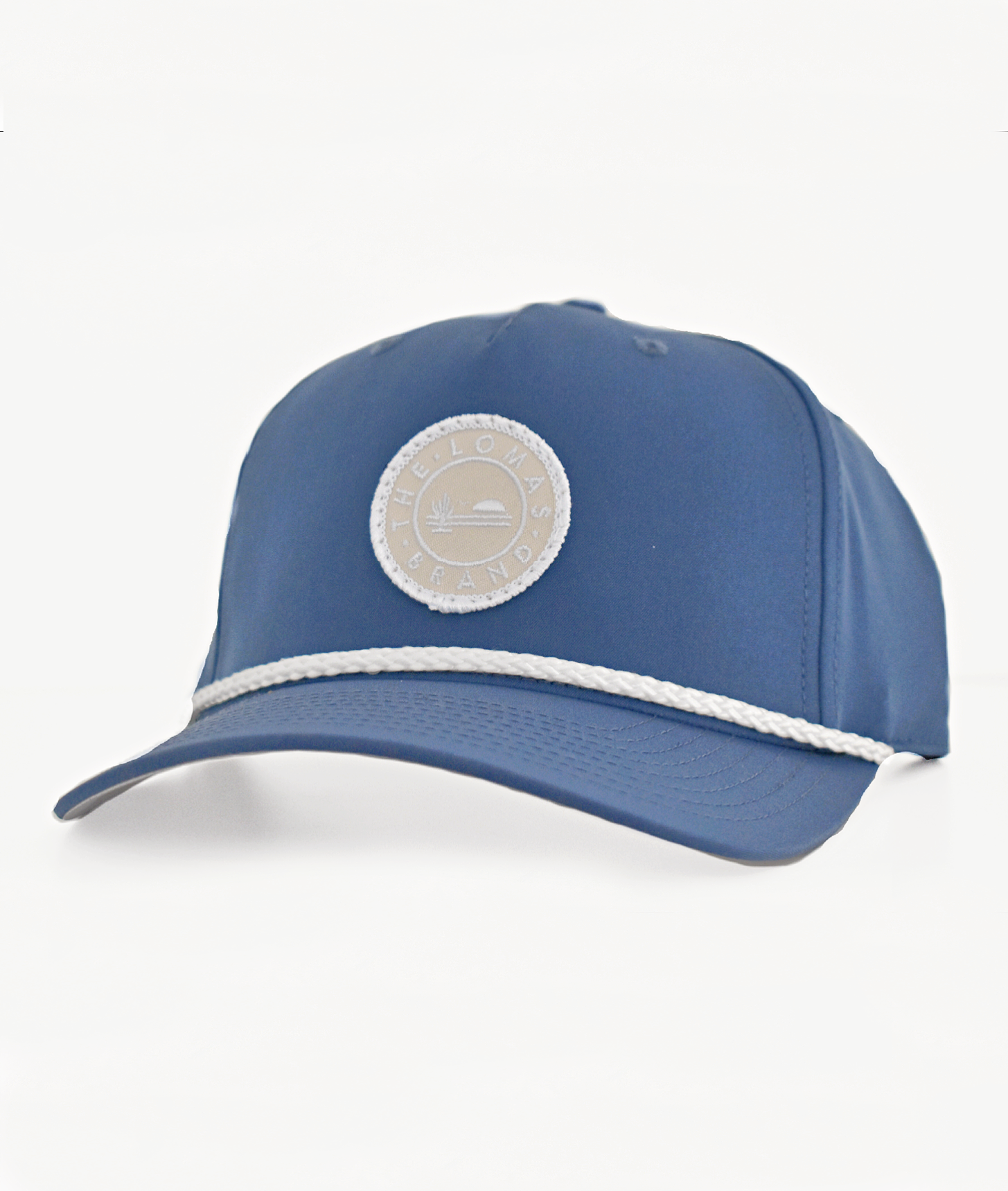 Deep royal blue hat with a fine beige braided rope across the front. Adjustable back strap for one-size-fits-most fit.  A beige patch on the front of the hat has "The Lomas Brand" written around the outside in white and a logo with a saguaro cactus, bird, and a rising sun on the inside, also in white.