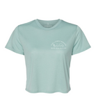 Indulge in sublime comfort with this teal tee, tailored for a cropped length hovering just above the waistline. The upper left chest features an emblematic local insignia rendered in crisp white - a stylized saguaro cactus with splayed limbs, a soaring silhouette of a bird, and an ascending sun. An arched wordmark reading "The Lomas Brand" is displayed above the emblem, while the phrase "Solana Beach, Calif. U.S.A" grounds the design below.