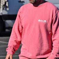 Man wearing a salmon colored sweatshirt with a small white graphic on the chest. Only the torso is visible. There's a vehicle in the background, suggesting this is in a parking lot or street setting.