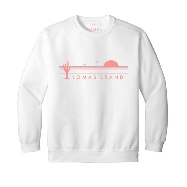 A white sweatshirt with "THE LOMAS BRAND" printed in pink on the front. The design features a stylized cactus and sunset graphic.