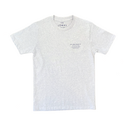 A light gray t-shirt with "THE LOMAS BRAND" printed on the collar tag. The shirt has a small text printed on the left chest area that reads "THE LOMAS BRAND CO." followed by additional text, "PREMIUM GRADE QUALITY GOODS," "DESIGNED IN NORTH COUNTY SAN DIEGO," and "SOLANA BEACH, CA EST 2015"